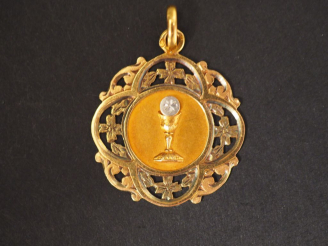 Vente aux enchères Médaille de baptême en or jaune, à décor de calice et de rinceaux. Poi