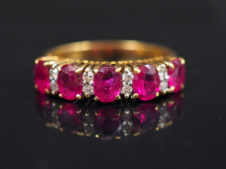 Vente aux enchères Bague pont en or jaune, sertie de rubis et petits diamants alternés. T