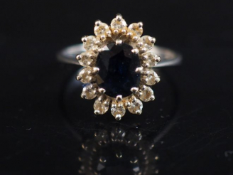 Vente aux enchères Bague marguerite en or blanc, sertie en son centre d'un saphir entouré
