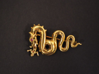 Vente aux enchères Broche en or jaune en forme de dragon crachant un petit enfant.  L'œil