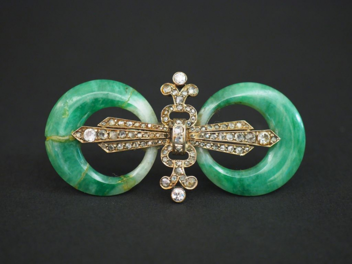 Broche 1900 deux anneaux de jade encadrant un fleuron orné de diamants