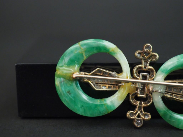 Broche 1900 deux anneaux de jade encadrant un fleuron orné de diamants