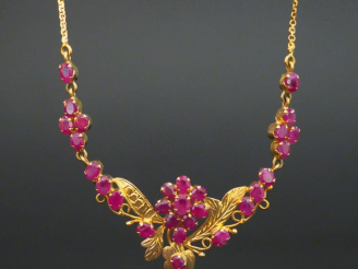 Vente aux enchères Pendentif et sa chaine en or orné de rubis à décor de fleurs. Poids te