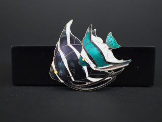 Vente aux enchères Broche art nouveau en argent et émail polychrome à décor de poissons.