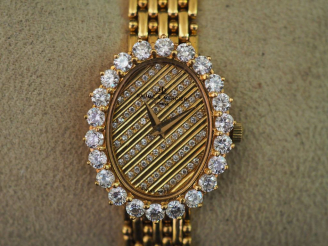Vente aux enchères BAUME ET MERCIER. Montre de dame en or, cadran entouré de 22 diamants,