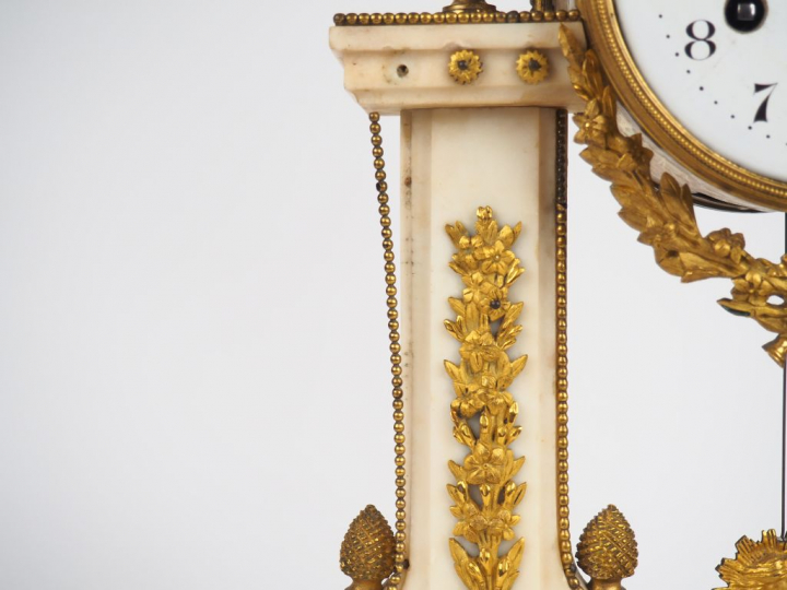 Pendule Louis XVI en marbre et bronze doré à décor de pommes de pins, 