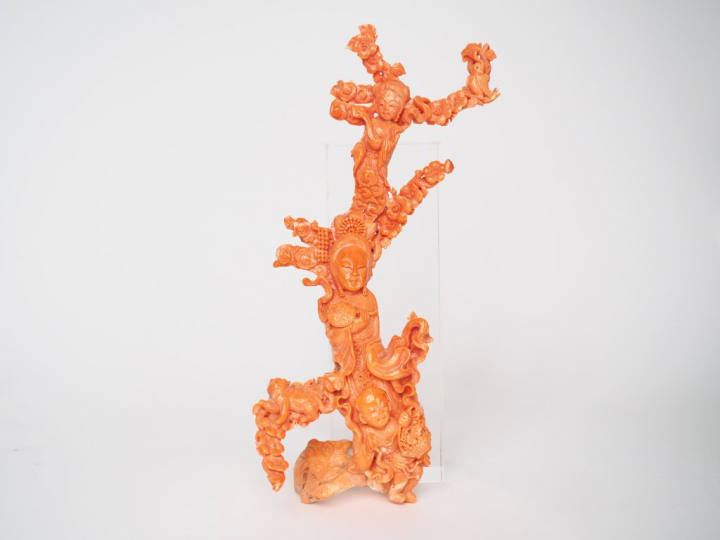 Statuette en corail couleur peau d'ange décor d'une divinité accompaag