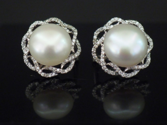 Vente aux enchères Paire de boucles d'oreilles en forme de fleur, perle de culture entour