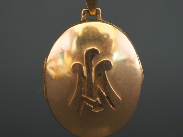 Pendentif porte-photo en or jaune, à décor appliqué de monogramme. Poi
