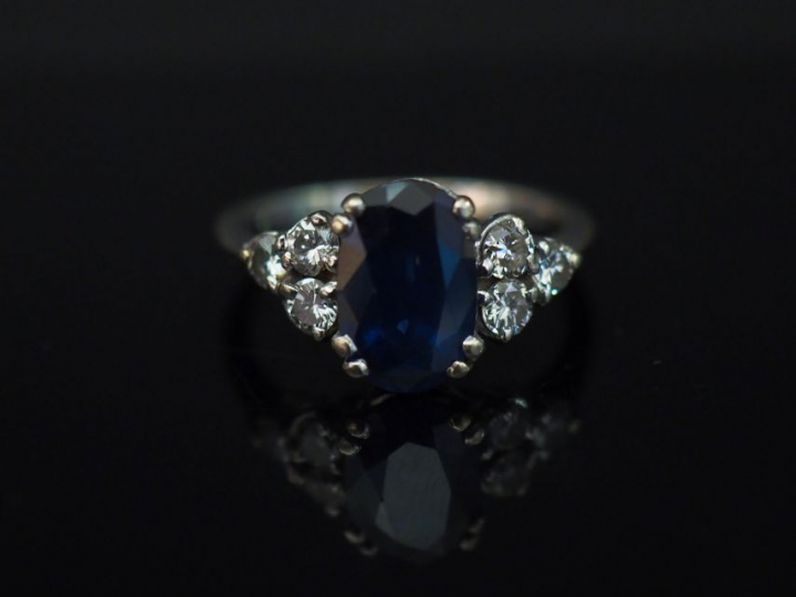 Bague en or blanc, sertie en son centre d’un saphir épaulé de trois pe