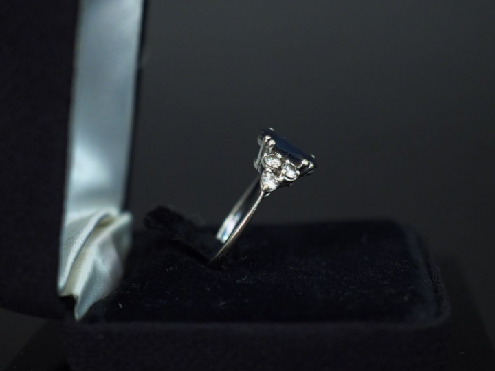Bague en or blanc, sertie en son centre d’un saphir épaulé de trois pe