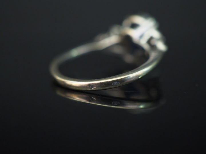 Bague en or blanc, sertie en son centre d’un saphir épaulé de trois pe