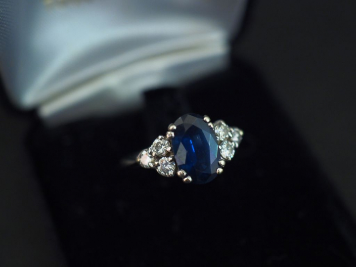 Bague en or blanc, sertie en son centre d’un saphir épaulé de trois pe
