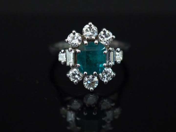 Bague marguerite en or blanc, sertie en son centre d’une émeraude ento
