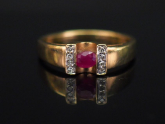 Vente aux enchères Bague moderne en or jaune, sertie en son centre d’une pierre rouge épa
