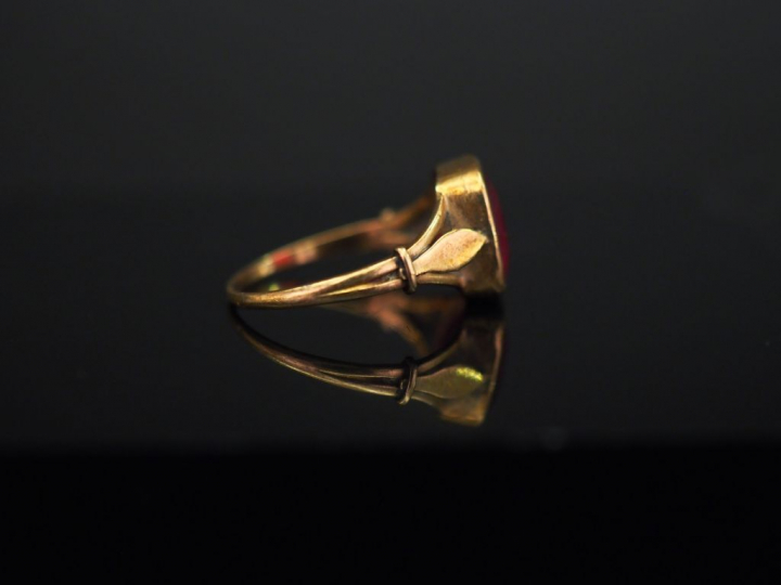 Bague en or jaune, sertie en son centre d’une pierre rouge. TDD. 52 Po