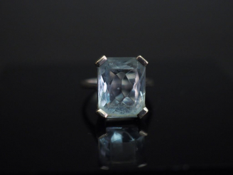 Vente aux enchères 	Bague en or banc, sertie en son centre d’une pierre bleue. TDD. 52 Po
