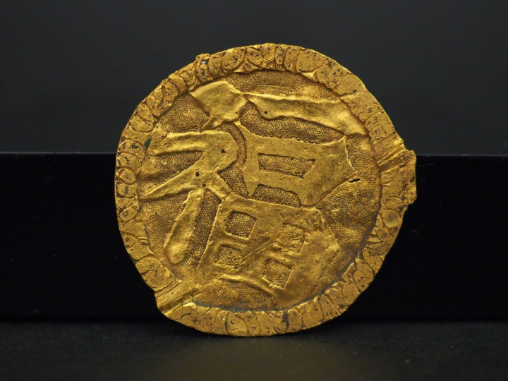 Elément de broche en or jaune, à décor de caractère chinois. Diam. 3,5