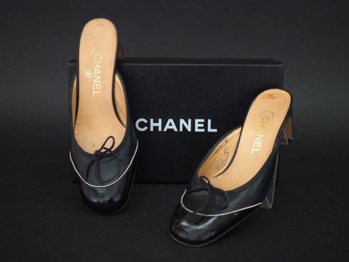 CHANEL. Paire de mules à talon en cuir noir et vernis, à décor sur le 