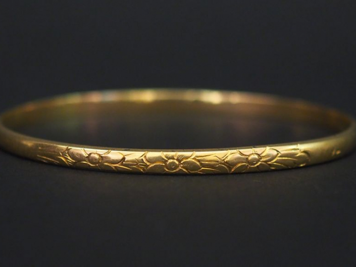 Jonc en or jaune, à décor de fleurs. Diam. 6,1 cm Poids. 15,50 g