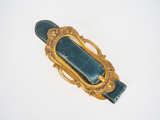 Vente aux enchères HERMES.  Pince à courrier en bronze et cuir vert, signée. L. 22 cm.