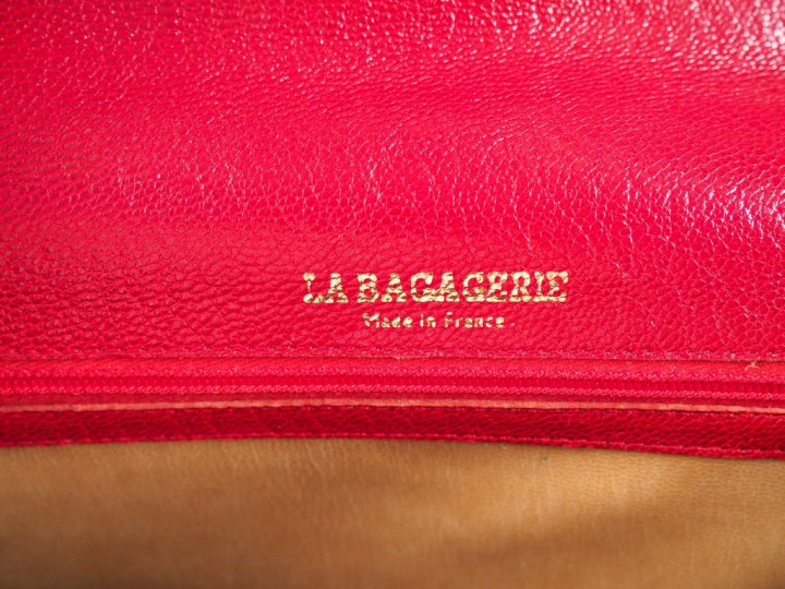 LA BAGAGERIE. Petit sac à main en cuir rouge. Signé