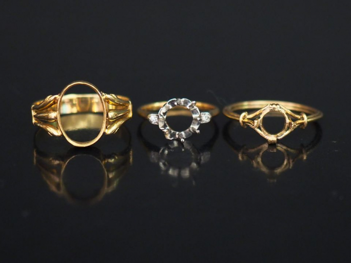 Trois différentes montures de bague en or jaune.  L'une sertie de deux