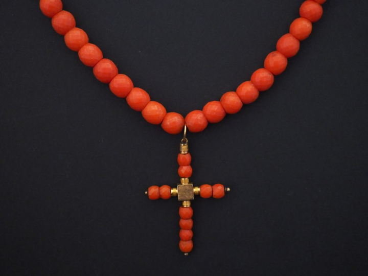 Collier de perles de corail facettées, serti en son centre d'un penden