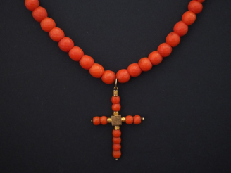 Vente aux enchères Collier de perles de corail facettées, serti en son centre d'un penden