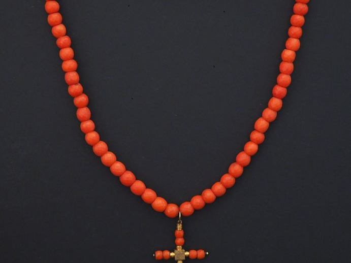 Collier de perles de corail facettées, serti en son centre d'un penden