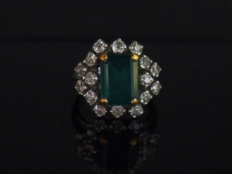 Vente aux enchères Bague marguerite en or blanc, sertie en son centre d’une émeraude ento