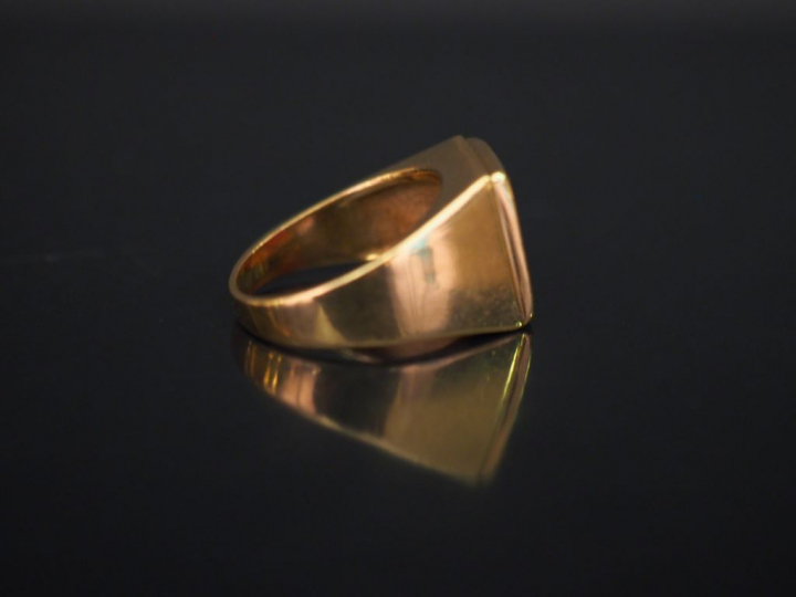 Bague de forme chevalière en or jaune, sertie en son centre d'une pier