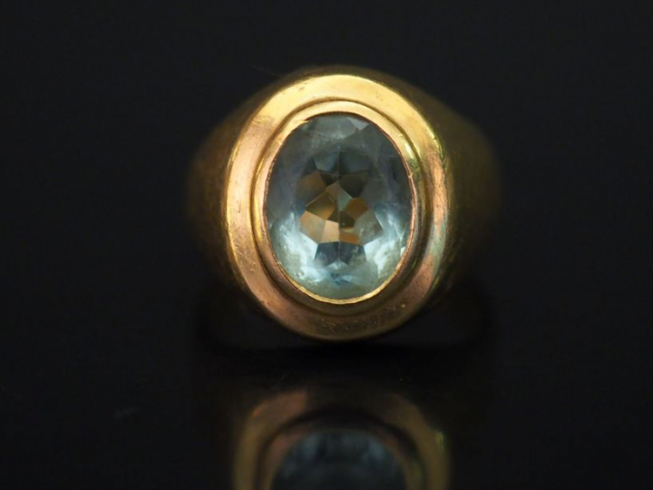 Bague de forme chevalière en or jaune, sertie d’une pierre bleu ciel. 