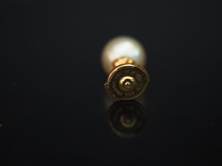 	Paire de perces oreilles en or jaune, serties d’une perle blanche. Sy