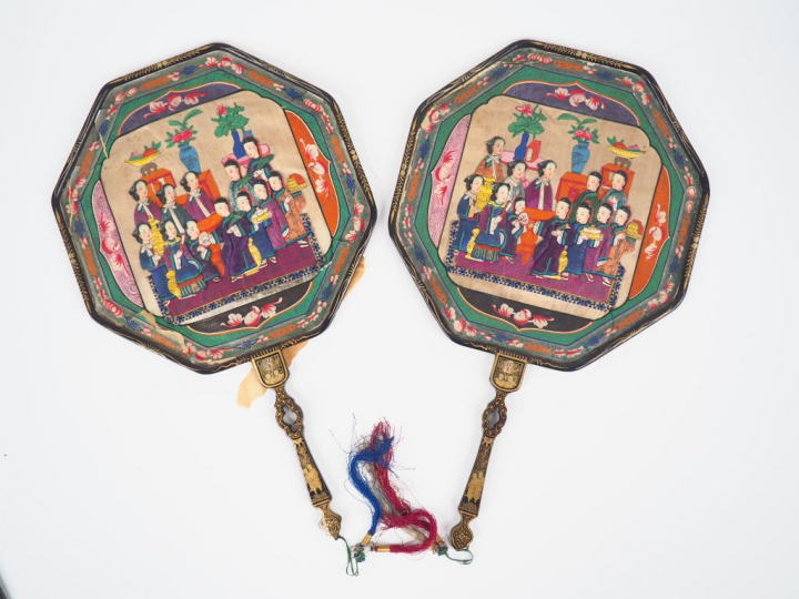 Paire d'éventails en bois laqué noir et or à décor de personnages et d
