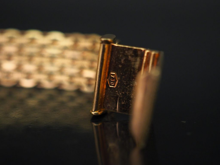 Bracelet articulé en or jaune, maille plate tressée, à décor en son ce