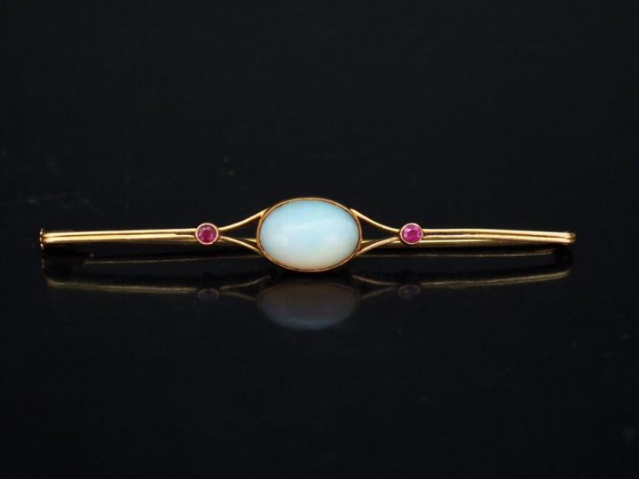 Broche barrette en or jaune, sertie en son centre d'une opale épaulée 