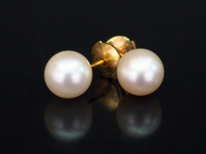 Paire de perce-oreilles en or jaune, sertis d'une perle blanche. Fermo