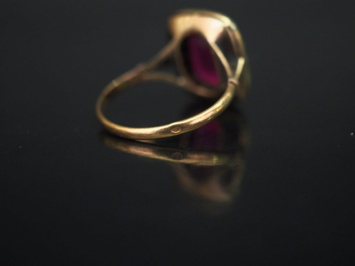 Bague en or jaune, sertie en son centre d’une pierre synthétique rose 