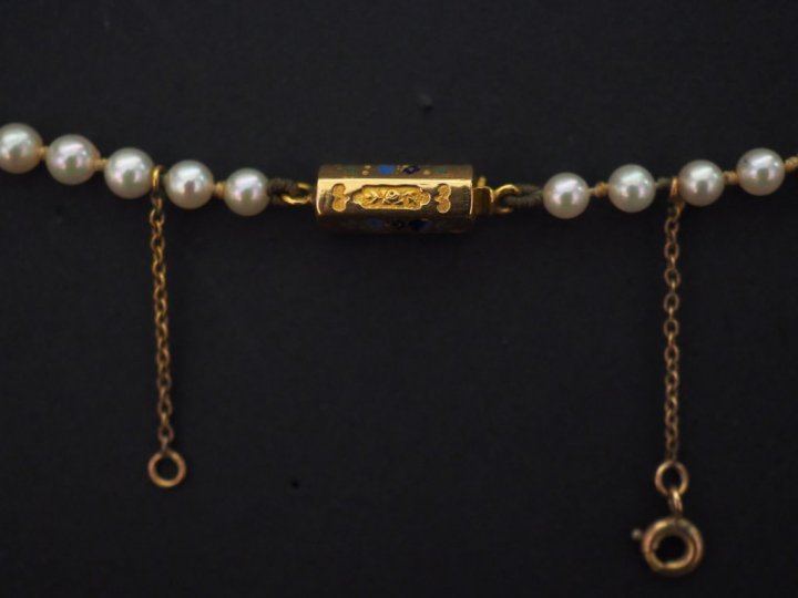 Collier de perles blanches disposées en chute.  Fermoir en or jaune, à