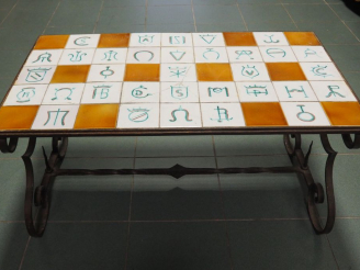 Vente aux enchères Table basse, plateau en céramique à décor de fers de manadiers. Dim. 4