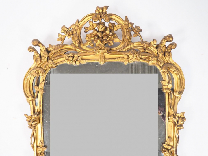 Glace Louis XV en bois sculpté et doré à décor de fleurs, de rocailles