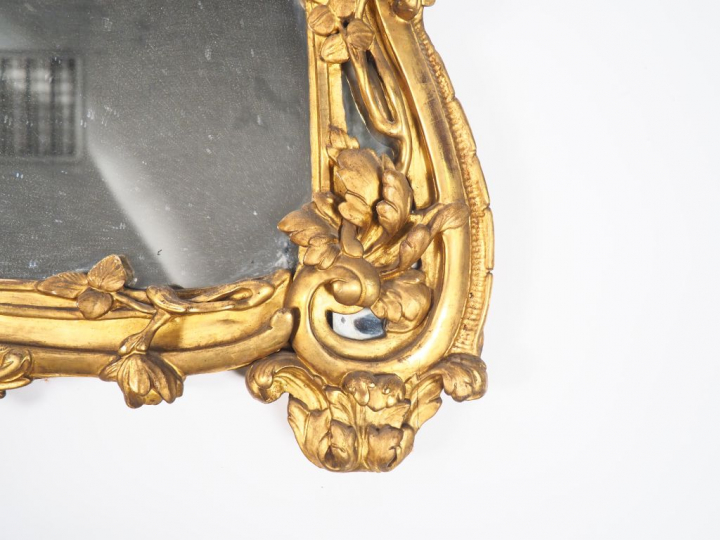 Glace Louis XV en bois sculpté et doré à décor de fleurs, de rocailles