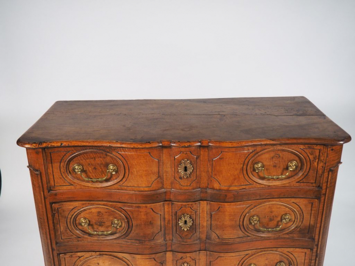 Commode Régence en noyer mouluré et sculpté ouvrant à 3 tiroirs, façad
