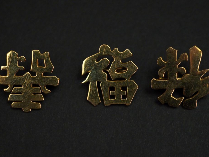 Trois petites broches en or jaune, figurant des caractères chinois.  1