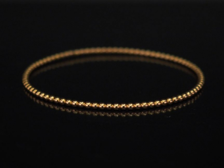 Bracelet jonc en or jaune, à décor de rang de perles. Diam. 6 cm Poids