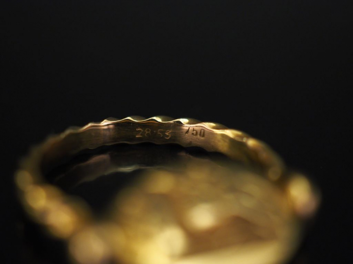 	Bague en or jaune, ornée en son centre d’un médaillon ovale imitant u