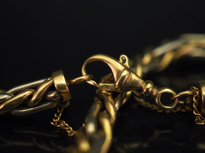 Bracelet souple deux tons d'or, maille tressée.  Chainette de sécurité