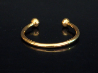 Vente aux enchères Bracelet jonc d'enfant en or jaune, à décor de boules aux extrêmités. 