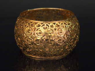 Vente aux enchères Bracelet manchette de forme bombée en or jaune, à décor ajouré de fleu
